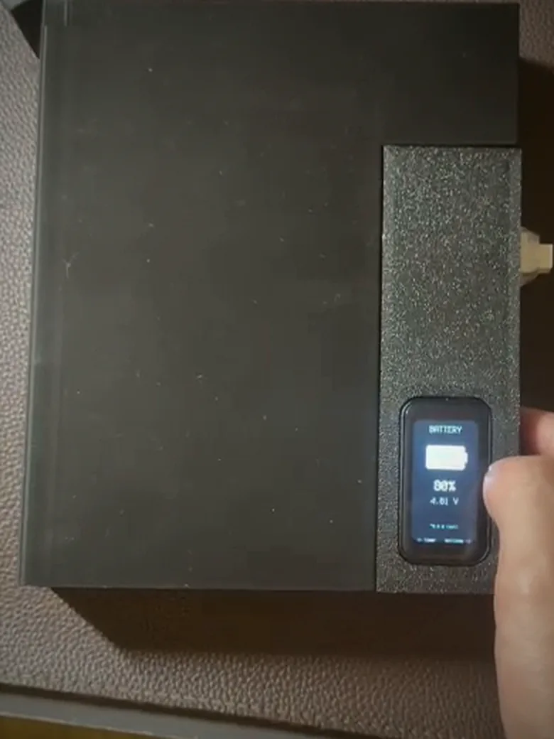 The finished Phone Box: a matte black 3D-printed enclosure with visible layer lines, its 1.47-inch touchscreen reading BATTERY, 88 percent, 4.01 volts, held in one hand.